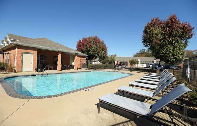 View of gated community pool with lounge chairs and access to community gym