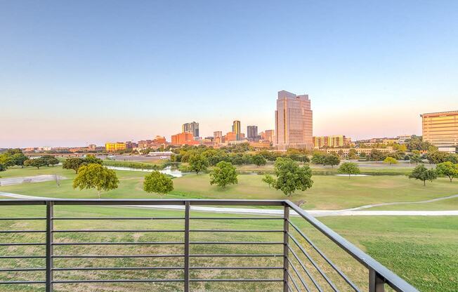 a view of the city skyline from a balcony overlooking a park