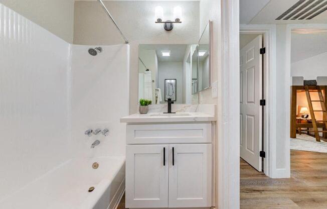 a bathroom with a sink and a tub and a mirror