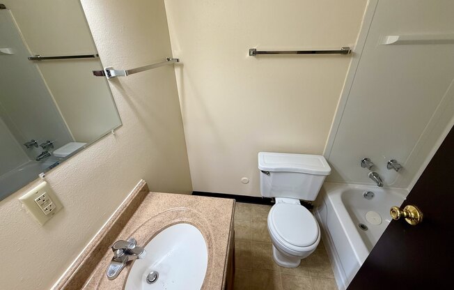 A bathroom with a toilet, sink, and bathtub.