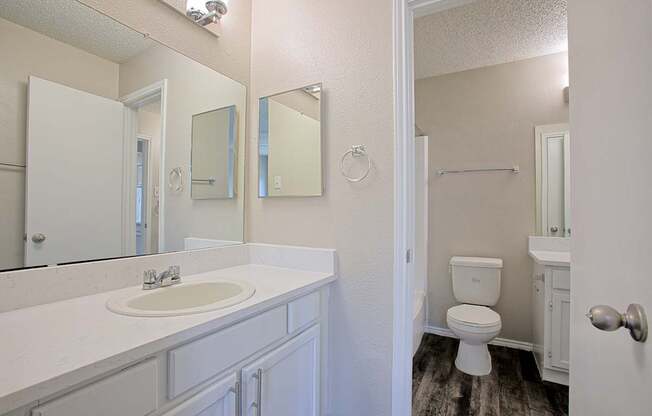 A bathroom with a white sink and toilet.