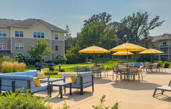 an outdoor patio with tables and chairs and umbrellas