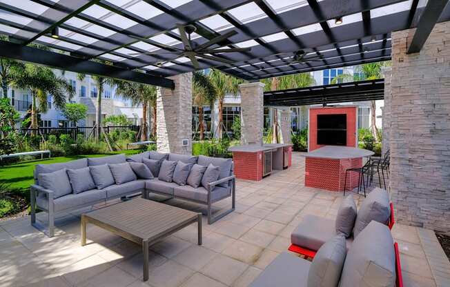 a patio with couches and tables under a pergola at Altis Grand Lake Willis, Florida