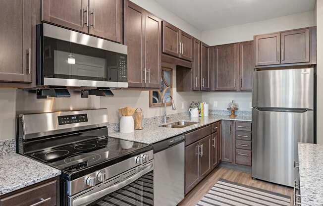 A kitchen with a stainless steel refrigerator, oven, and microwave.