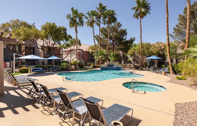 a swimming pool with chairs and umbrellas and palm trees