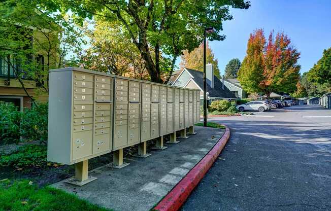 A row of mailboxes are lined up on the side of a street.