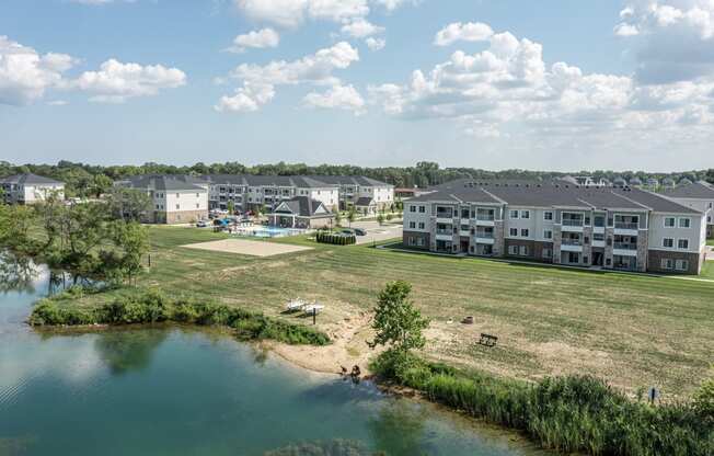 Pond view of community, kayak storage and beach area with community in background.