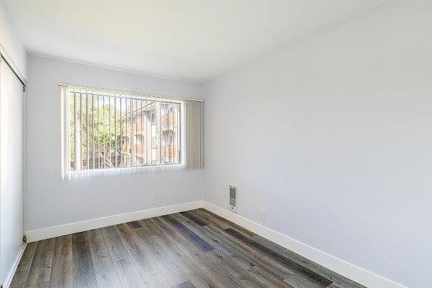 A room with a window and wooden flooring.