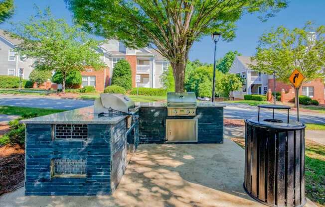 A blue dumpster sits in the foreground of a residential street.