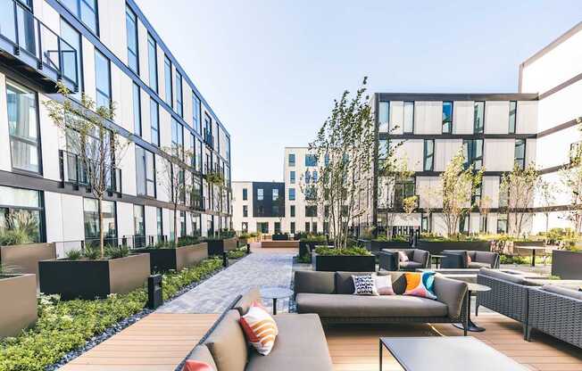 A modern outdoor seating area with couches and tables.