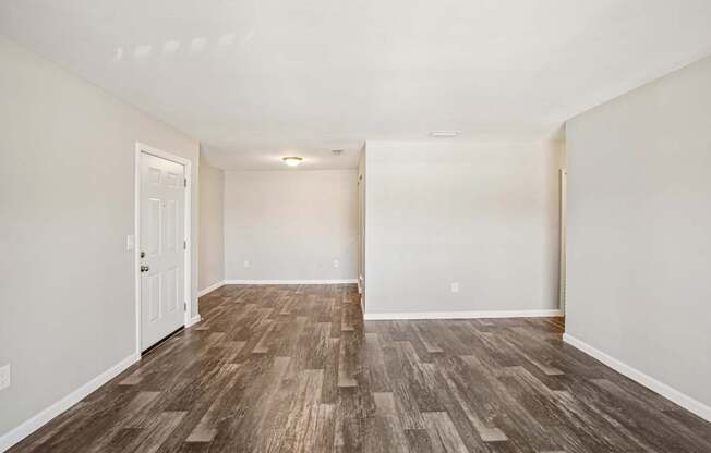 A room with wooden flooring and white walls.
