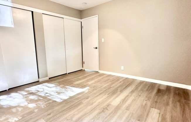 an empty living room with wood flooring and a ceiling fan