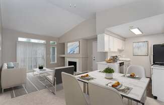 a living room with a dining room table and chairs and a fireplace in the background