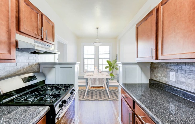 kitchen with stainless steel appliances, modern countertops and view of dining area at the frontenac apartments in washington dc