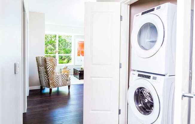 Compact stacked washer and dryer nestled in a hallway closet, providing convenient laundry facilities in a stylish apartment.