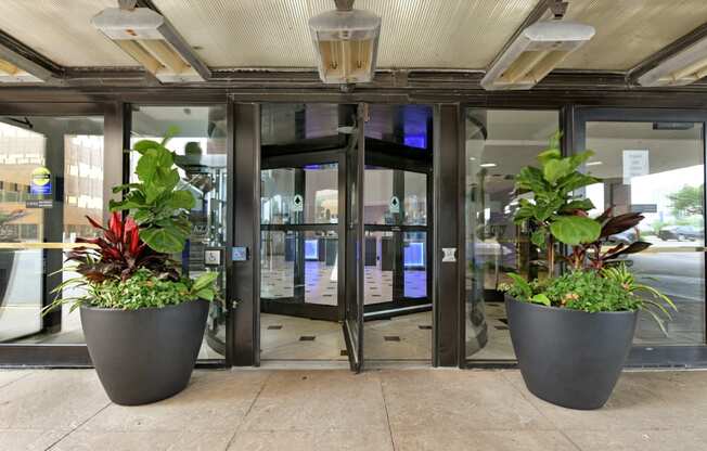 an entrance to a building with two large planters in front of the door