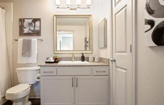 a bathroom with a sink toilet and a mirror at Volare at the Woodlands, The Woodlands, 77384