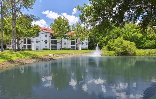 a large pond with a fountain in front of a building