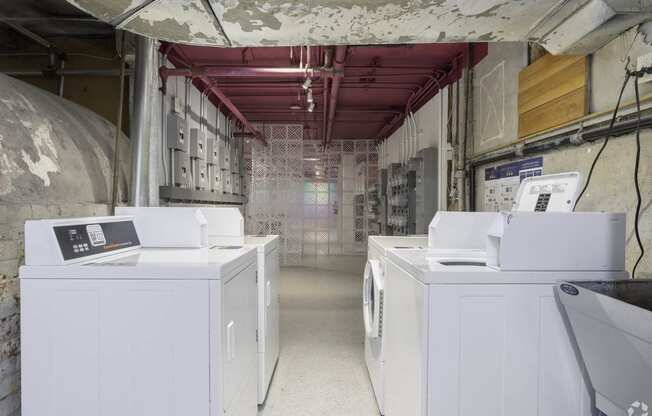 a laundry room with four washing machines in it at Clay & Tiffany, Portland, 97201