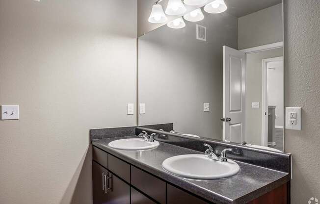 an empty bathroom with two sinks and a large mirror