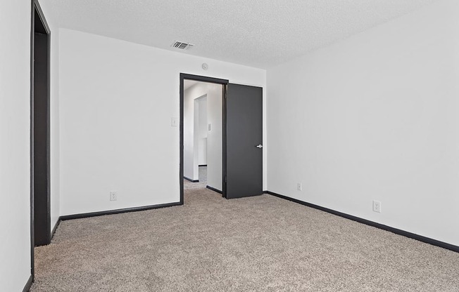 an empty living room with a door to a closet