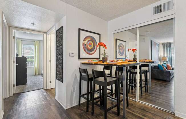 A dining room with a wooden table and chairs.