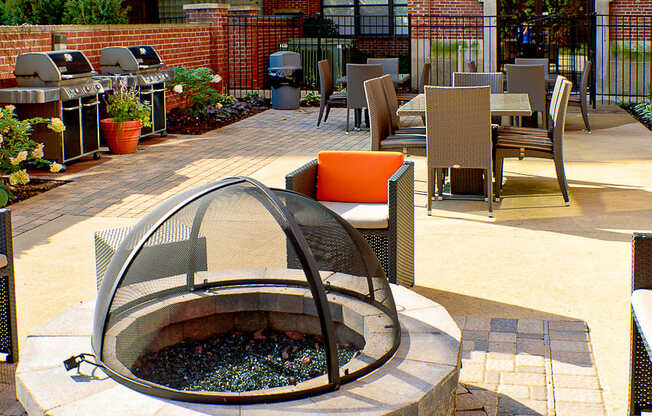a courtyard with a fire pit and tables and chairs