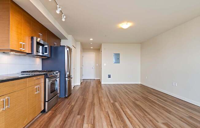 A kitchen with wooden floors and a blue refrigerator.