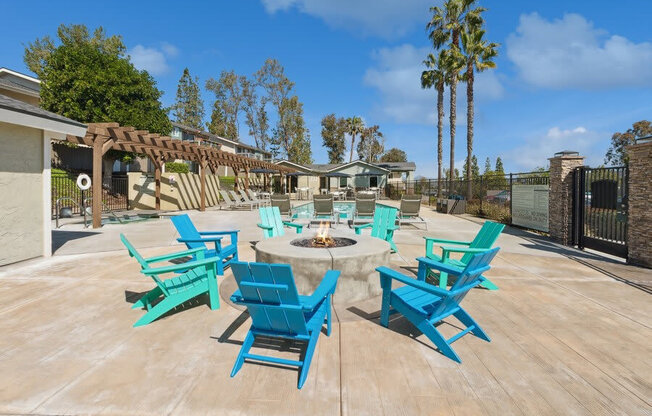 Community Fire Pit surrounded with Blue Chairs at Forest Park Apartments in El Cajon, CA.