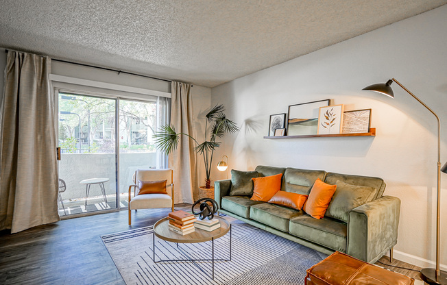 Private balcony glass doors and sofa in platinum living room interior at Treehouse in Albuquerque NM