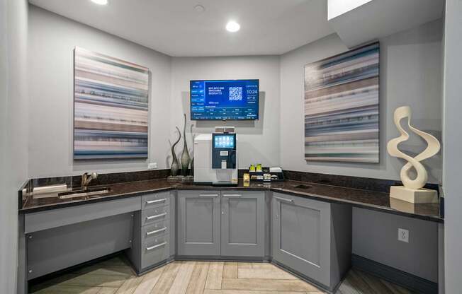 A modern kitchen with a wooden floor and grey cabinets.