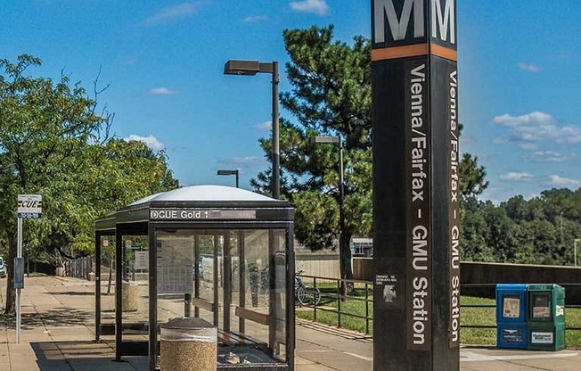 a bus stop with a sign and a bench