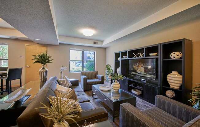 A living room with a brown couch, chairs and a coffee table.