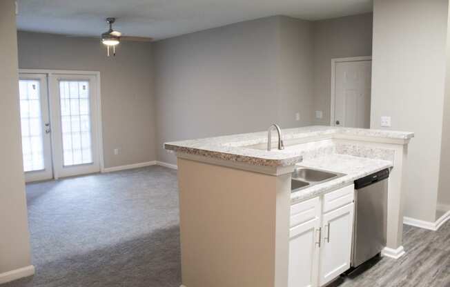 Enclave at Wolfchase Apartments in Cordova Tennessee photo of a kitchen with an island and an empty living room in the background