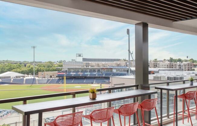 a view of a baseball stadium from a balcony with tables and chairs
