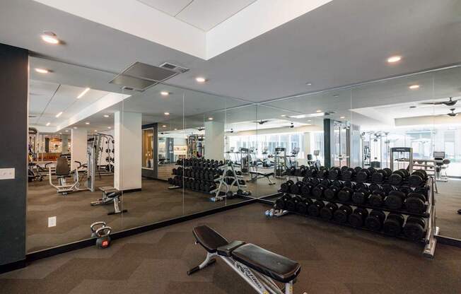 A gym with a variety of equipment including weights and cardio machines.
