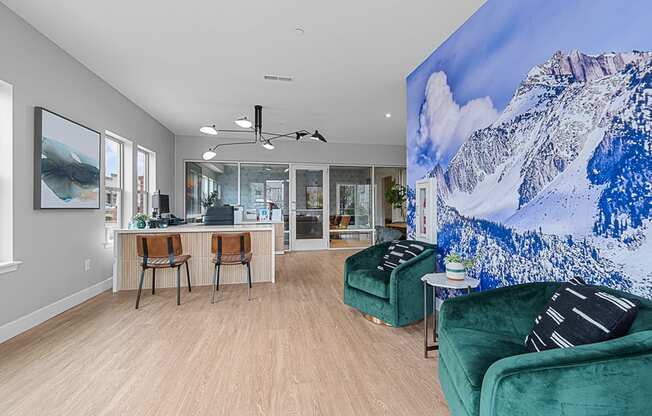 a living room with a large painting of a mountain on the wall and two green couches