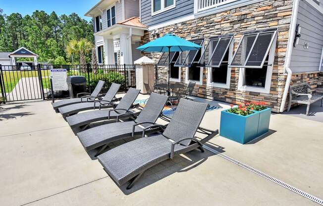 our apartments showcase a large patio with lounge chairs and a fire pit