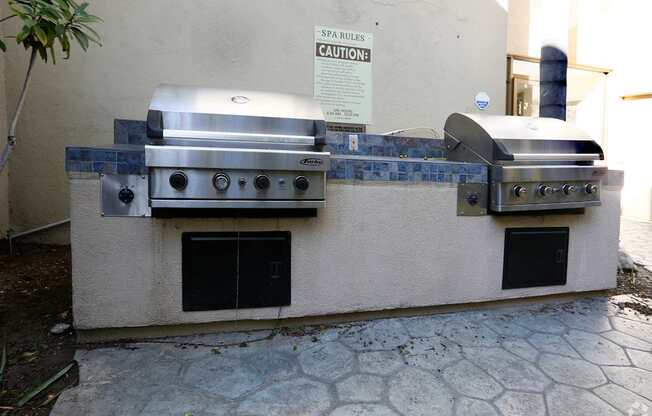 A stainless steel grill with a caution sign on the wall.