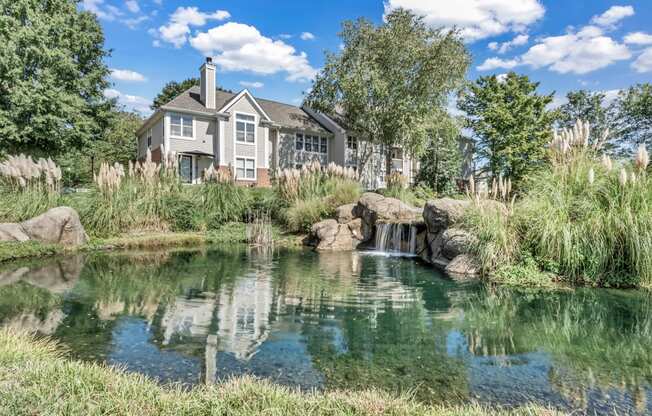 a pond with a house in the background