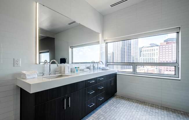a bathroom with a large window and a counter with a sink