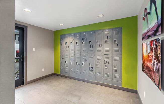A row of metal lockers numbered from 09 to 18 are lined up against a green wall.