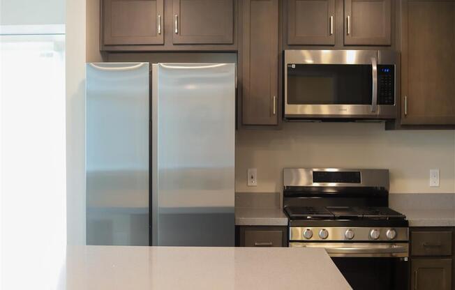 kitchen with a refrigerator stove and microwave at Loma Villas Apartments, San Bernardino, CA