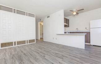A kitchen with white cabinets and a white refrigerator.