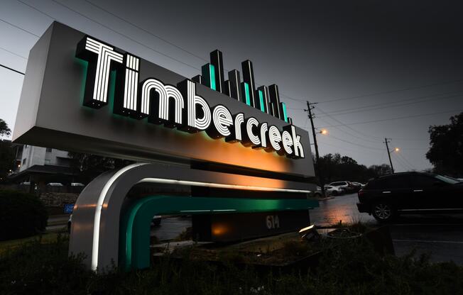 a sign for the tilden corporation in front of a parking lot at night