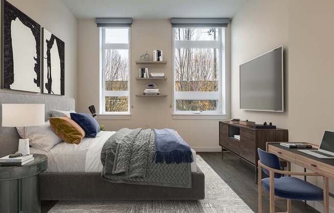 A bedroom with a bed, desk, and chair.