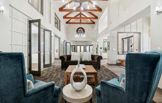 A large, modern room with a high ceiling and a mix of dark and light furnishings.