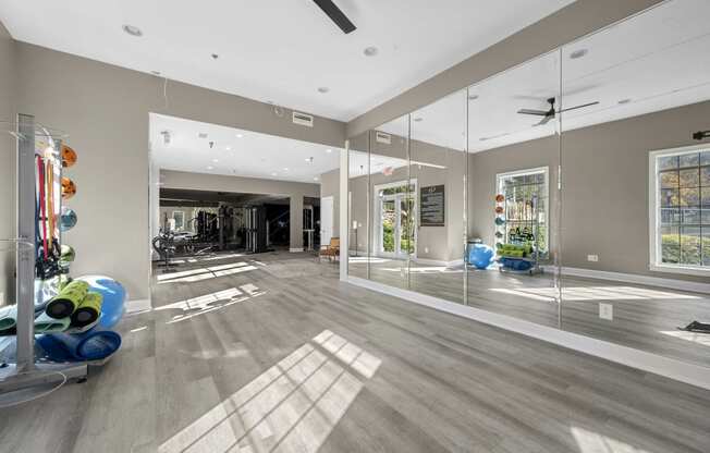 a gym with mirrors in a large room with hardwood floors