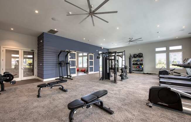 a home gym with exercise equipment and a ceiling fan