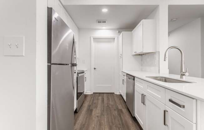 a renovated kitchen with white cabinets and stainless steel appliances